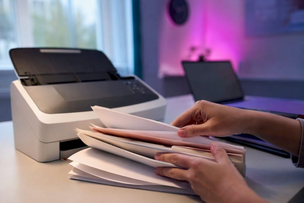 Hands loading documents into scanner